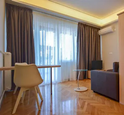 a living room with a table and a couch at Athens Luxury Apartments Rodos in Athens