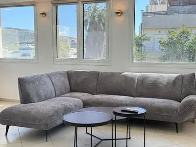 a living room with a couch and two tables at Beachfront 3bedroom apartment in Porto Rafti