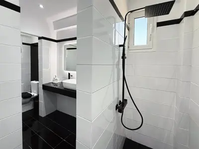 a white bathroom with a shower and a sink at Beachfront 3bedroom apartment in Porto Rafti