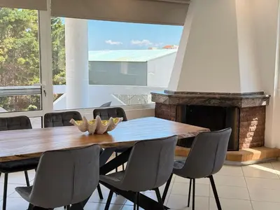 a dining room with a table and chairs and a fireplace at Beachfront 3bedroom apartment in Porto Rafti