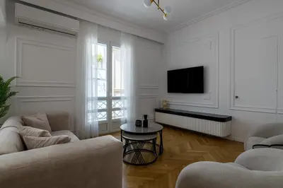 a living room with two couches and a tv at Plaka Elegance Retreat in Athens