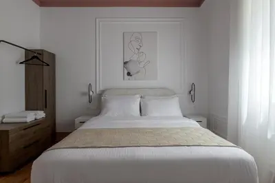 a white bedroom with a bed and a picture on the wall at Plaka Elegance Retreat in Athens