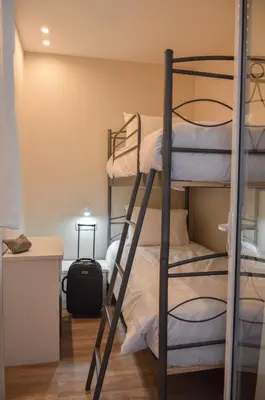 a room with two bunk beds and a kitchen at Athens Luxury Apartments Lindos in Athens