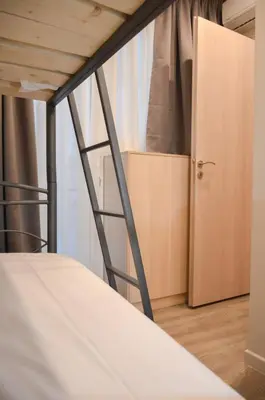 a bunk bed with a ladder next to a closet at Athens Luxury Apartments Lindos in Athens