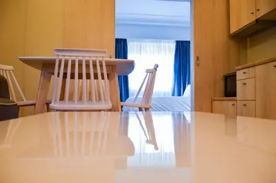 a kitchen with a table and two wooden chairs at Athens Luxury Apartments Lindos in Athens