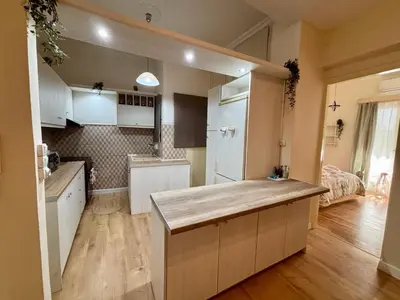 a kitchen with white cabinets and a kitchen island at Casa Philoxenia, Acropolis District in Athens