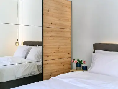 a bedroom with two beds and a large wooden headboard at CorNeliApartment in Athens