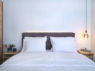 a bed with white sheets and pillows in a bedroom at CorNeliApartment in Athens