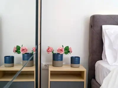 a bedroom with two tables with flowers in a mirror at CorNeliApartment in Athens