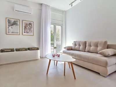a living room with a couch and a table at CorNeliApartment in Athens