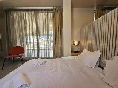 a large white bed in a room with a window at Skynest Studio byYHA in Athens