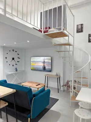 a living room with a staircase and a blue couch at Glyfada Seabreeze Loft B in Athens