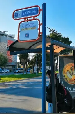 a man is sitting at a bus stop at Glyfada Seabreeze Loft B in Athens