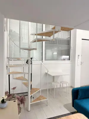 a living room with a spiral staircase in a house at Glyfada Seabreeze Loft B in Athens