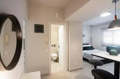 a bedroom with a bed and a mirror on the wall at Aminandrou Boutique Apartments, Walk to Acropolis in Athens