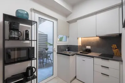 a kitchen with white cabinets and a microwave at Aminandrou Boutique Apartments, Walk to Acropolis in Athens