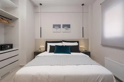 a bedroom with a large bed with a blue pillow at Aminandrou Boutique Apartments, Walk to Acropolis in Athens