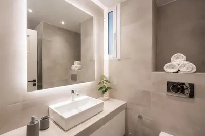 a bathroom with a white sink and a mirror at Aminandrou Boutique Apartments, Walk to Acropolis in Athens