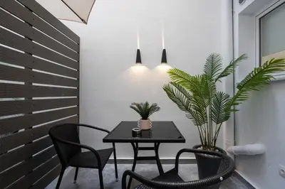 a dining room with a table and chairs and plants at Aminandrou Boutique Apartments, Walk to Acropolis in Athens