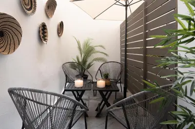 a patio with two chairs and a table with candles at Aminandrou Boutique Apartments, Walk to Acropolis in Athens