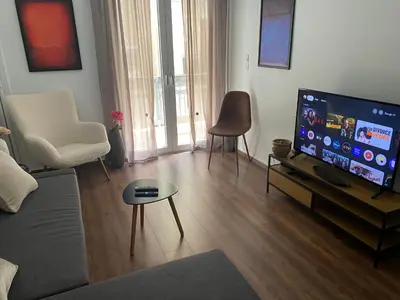 a living room with a large flat screen tv at Cozy & Connected, Walk to Culture, Metro in Minutes in Athens