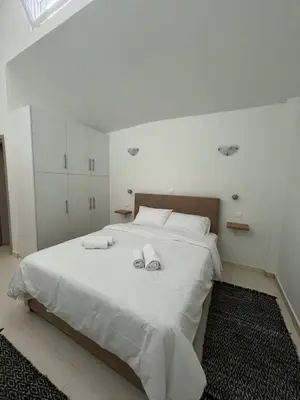 a bedroom with a white bed with towels on it at Jimilio 2 in Spáta