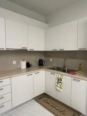 a kitchen with white cabinets and a sink at Jimilio 2 in Spáta