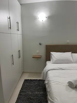a bedroom with a bed and a cabinet and a rug at Jimilio 2 in Spáta