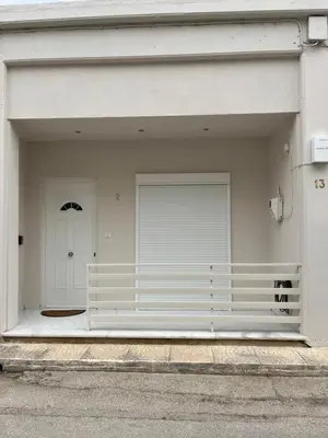 a white garage with a white door and a gate at Jimilio 2 in Spáta
