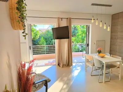 a living room with a table and a tv and a table and chairs at Vouliagmeni Top Floor Maisonette in Athens