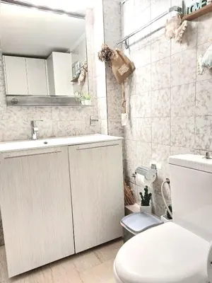 a white bathroom with a toilet and a sink at Vouliagmeni Top Floor Maisonette in Athens