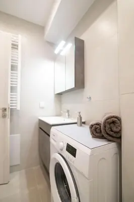 a white laundry room with a washer and dryer at Nafsika Cozy Flat A - Glyfada in Athens
