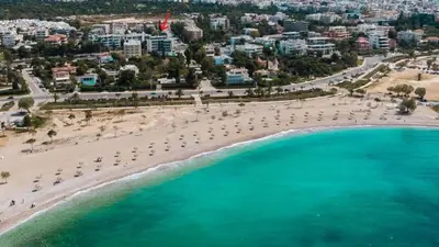 an aerial view of a beach with umbrellas and the ocean at Nafsika Cozy Flat A - Glyfada in Athens