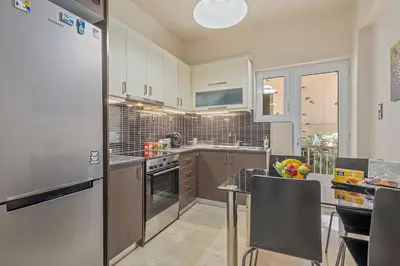 a kitchen with a stainless steel refrigerator and a table at 3BD Luxury Apartment close to Metro in Athens