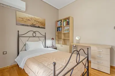 a bedroom with a bed and a book shelf at 3BD Luxury Apartment close to Metro in Athens