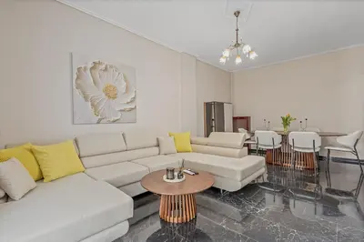 a living room with a white couch and a table at 3BD Luxury Apartment close to Metro in Athens