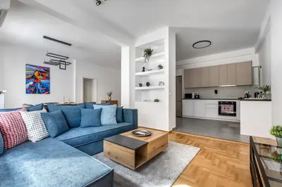 a living room with a blue couch and a table at Cozyopolis - Timeless 3-BR Escape in Athens in Athens
