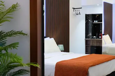 a bedroom with a bed with white sheets and an orange blanket at Dema Luxury Suites - Romvis in Athens