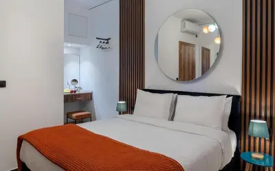 a bedroom with a large bed and a mirror at Dema Luxury Suites - Romvis in Athens