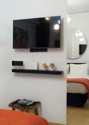 a room with a tv on a wall with a bed at Dema Luxury Suites - Romvis in Athens