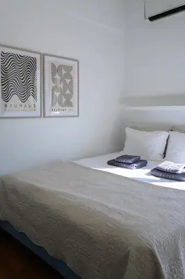 a white bed with two pillows on top of it at Sunbathed Balcony - Philopappou View in Athens