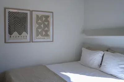 a bedroom with a bed with a picture on the wall at Sunbathed Balcony - Philopappou View in Athens