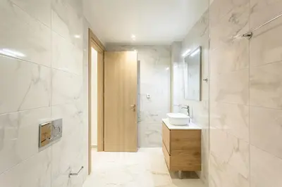 a white bathroom with a sink and a mirror at Grec Suites Dafni, Athens by GrecCollection in Athens
