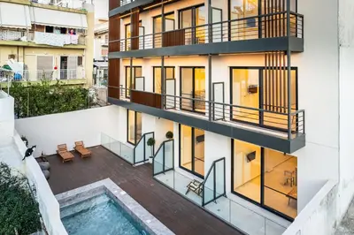 an apartment building with a swimming pool and a balcony at Grec Suites Dafni, Athens by GrecCollection in Athens
