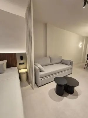 a living room with a couch and two tables at Shape Suites Athens in Athens