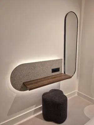a mirror on a wall next to a stool and a stool at Shape Suites Athens in Athens