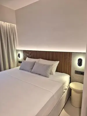 a bedroom with a white bed and a toilet at Shape Suites Athens in Athens