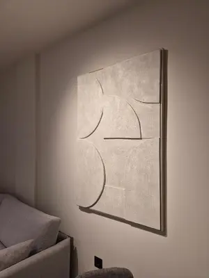a painting hanging on a wall next to a couch at Shape Suites Athens in Athens