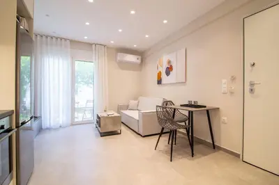 a living room with a table and a couch at Nafsika Cozy Flat B - Glyfada in Athens