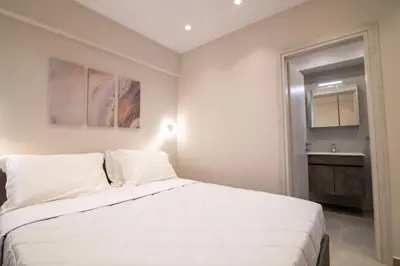 a bedroom with a white bed and a sink at Nafsika Cozy Flat B - Glyfada in Athens